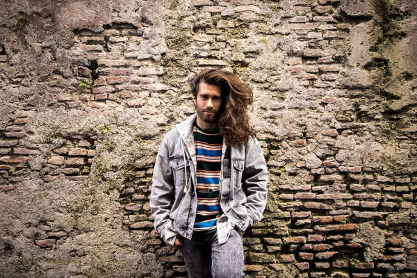 Genç grunge adam eski tuğla-taş zemin üzerine poz 