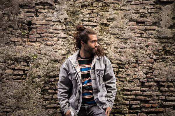 Joven Hipster Hombre Posando Sobre Viejo Ladrillo Piedra Fondo — Foto de Stock