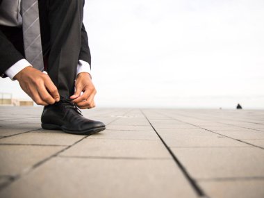 Adam ayakkabılarını bağlama