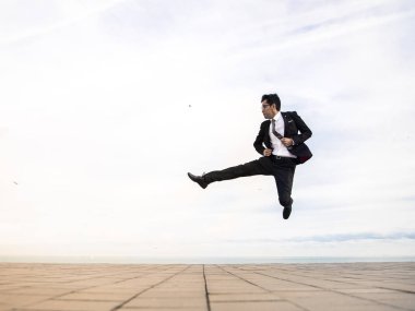 Genç adam bir takım elbise ve açık atlama