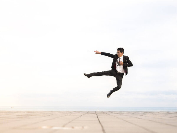 young man wearing a suit and jumping outdoor