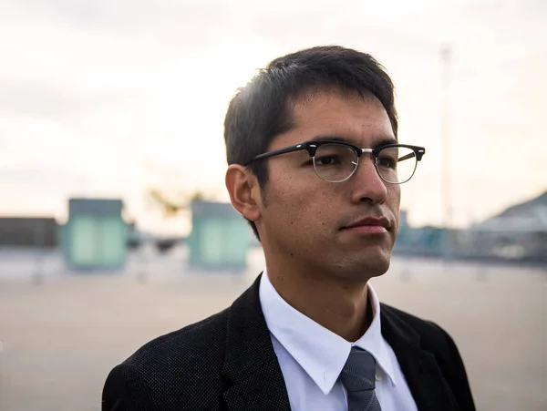 South american guy posing wearing a suit and glasses