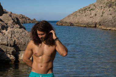 Kaslı adam çıplak gövde blue Bay'de dinlenme ile gülümseyen genç