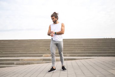 Genç adam SmartWatch yoğun eğitim önce denetleme  