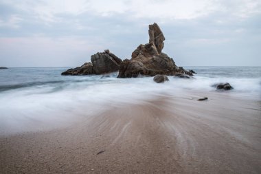 Mavi dalgalı okyanus sert kayalarda doğal görünümünü 