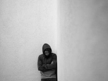 Hoody ışık gri duvara poz içinde sakallı adam vurguladı