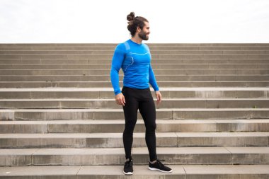 Dış eğitim egzersizleri arasında oturan genç adam  