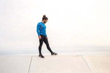 Dış eğitim egzersizleri arasında oturan genç adam  