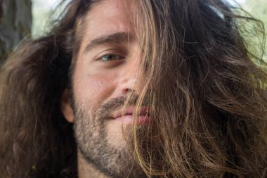 Uzun siyah saçlı adam gülümseyen sakal portresi Görünümü Kapat