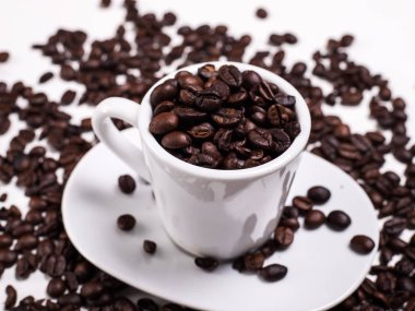 Kahve çekirdekleri arka plan üzerinde beyaz kahve fincanı aroma kahve çekirdekleri ile görünümünü kapat