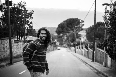 Genç şık sakallı adam boş yolda yürürken