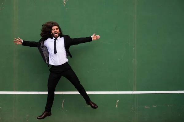 Brutal Hombre Barbudo Saltando Traje Negro Delante Pared Verde — Foto de Stock