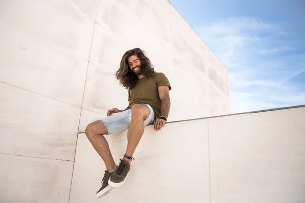 Joven Con Pelo Largo Sentado Pared Piedra Caliza — Foto de Stock