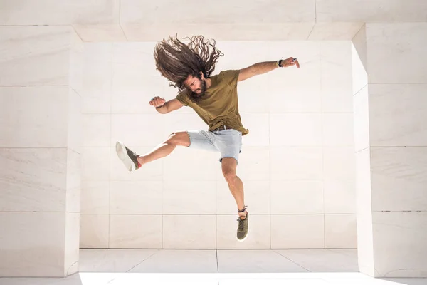 年轻的运动的人有乐趣和跳跃在石灰石大厦 — 图库照片
