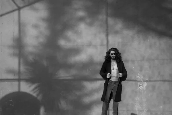 Mladý Vousatý Muž Holé Torzo Pózuje Černém Kabátě Šedou Stěnu — Stock fotografie