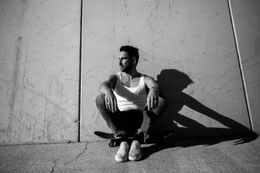 Duvar, siyah beyaz fotoğraf yakın kaykay üzerinde oturan yakışıklı adam 