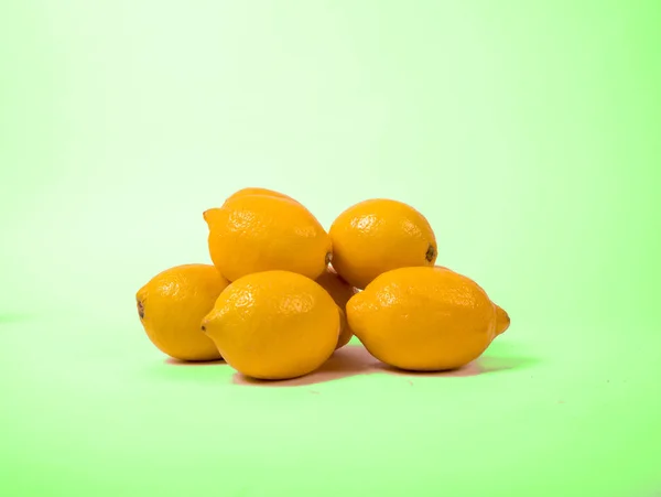 fresh yellow lemons isolated on green background