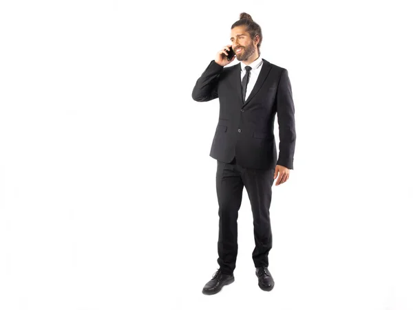 siyah takım elbiseli yakışıklı genç işadamı beyaz izole telefonla konuşurken