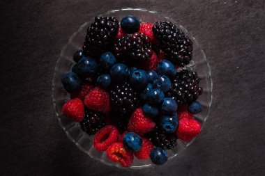 Islak ahududu, yaban mersini ve böğürtlenleri cam bir kaseye koy. 