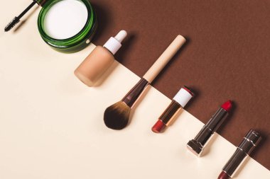 kahverengi ve krem rengi arkaplanda makyaj malzemesi