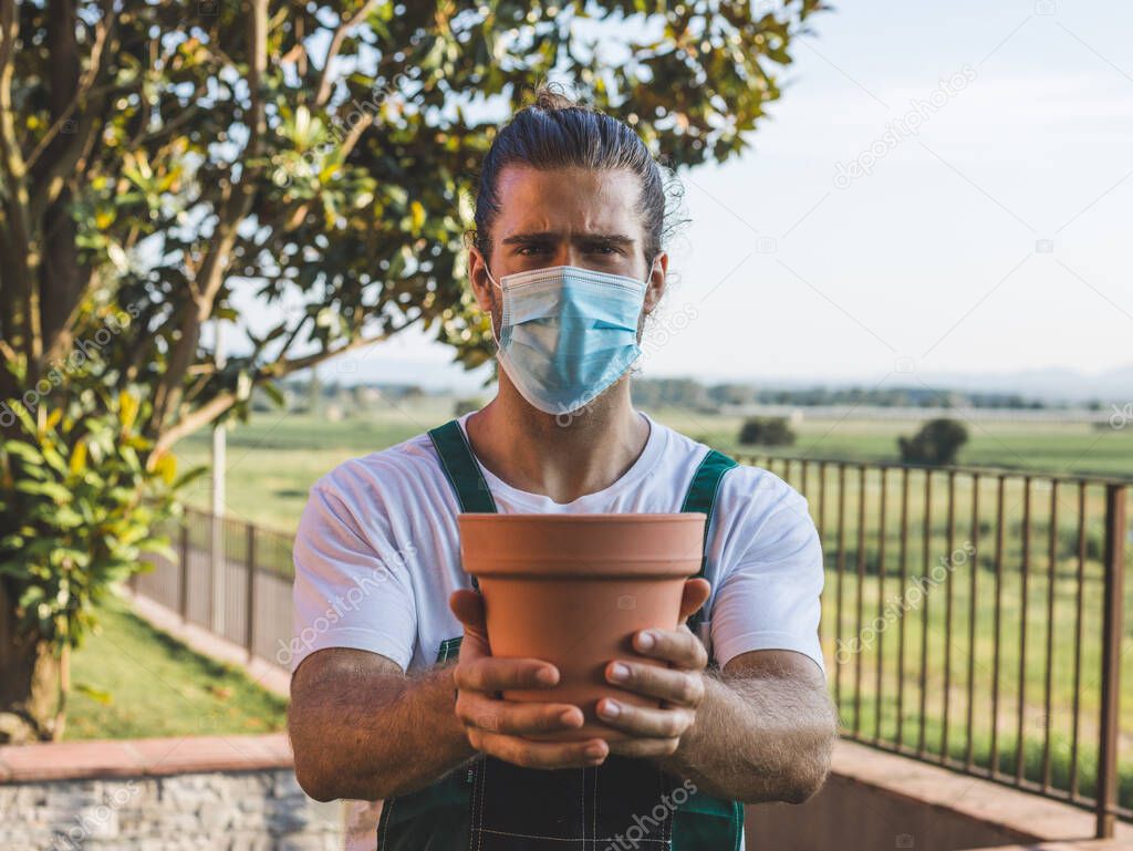 a gardener wearing a mask selling a pot