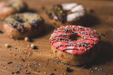 Tahta bir masada renkli çörekler ve biraz şekerleme.