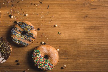 Tahta bir masada renkli çörekler ve biraz şekerleme.