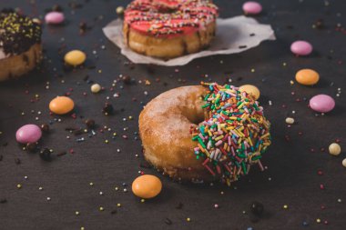 Siyah bir masada renkli çörekler.