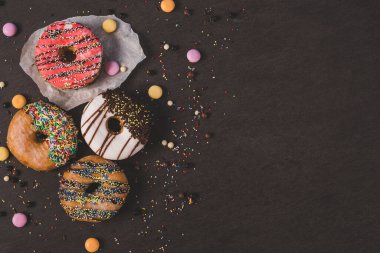 Siyah bir masada renkli çörekler.