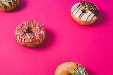 Pembe arka planda renkli donutları kapat 
