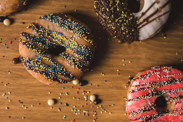 Bunte Donuts Auf Einem Holztisch Mit Ein Paar Bonbons — Stockfoto