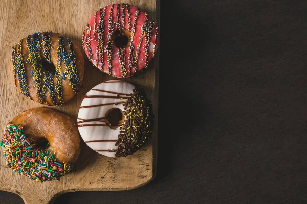 Bunte Donuts Auf Einem Holztisch Mit Schwarzem Hintergrund — Stockfoto