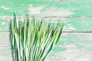 Buğday kulaklarının yeşil ahşap bir arka planda yakın plan görüntüsü.