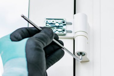 Eldiven işçisi plastik kapıyı ayarlar.