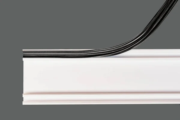 Eldivenli bir işçi beyaz bir pencere profiline plastik bir bant yerleştirir.