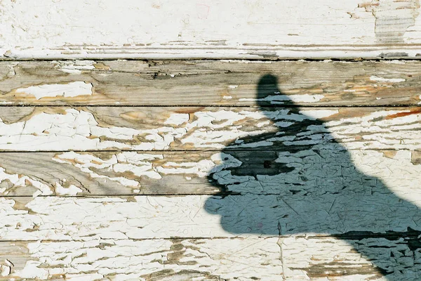 古い木製の盾に手のジェスチャーの影に亀裂塗料 — ストック写真