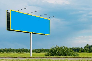 Yolun kenarında duran büyük bir reklam afişi.