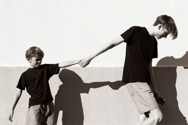 小さな男の子が家の中庭で兄と遊んでいる 白黒写真 — ストック写真