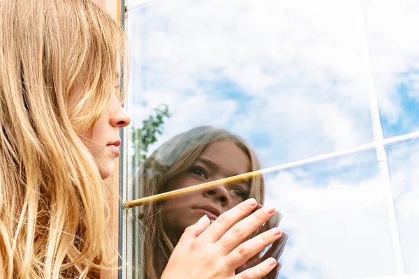 Het Meisje Kijkt Naar Haar Spiegelbeeld Het Raam — Stockfoto