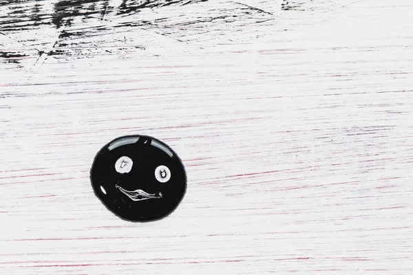 Funny smiley face drawn in black paint on a decorative surface