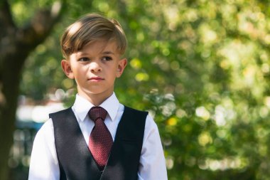 Üniformalı küçük bir çocuk okula hazırlanıyor.