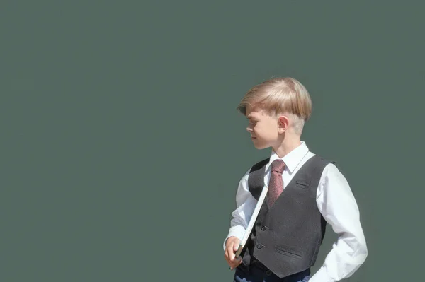手に本を持って制服を着た小さな男の子が学校の準備をしています — ストック写真