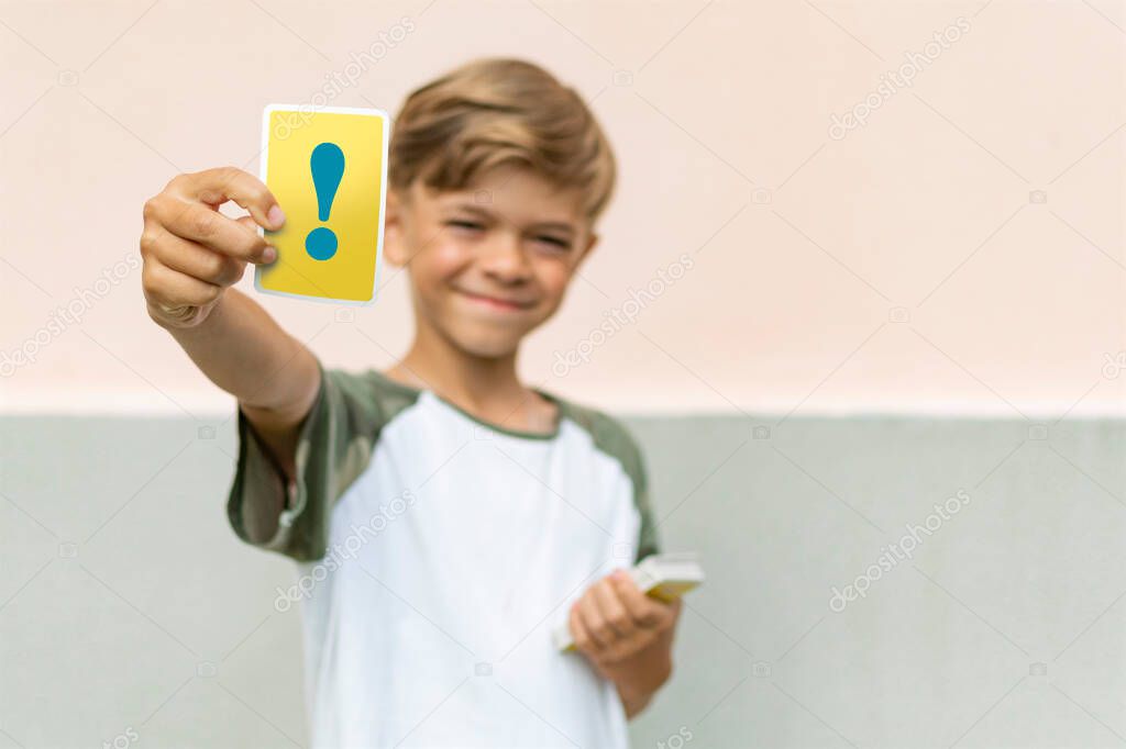 The little boy holds in his hands the card of paper for the game