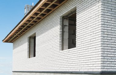 Windows olmadan inşa edilen yeni bir ev. Beyaz tuğla ustalığı