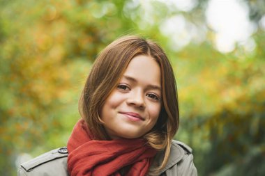 Sonbahar elbiseli genç bir kız parkta dinleniyor.