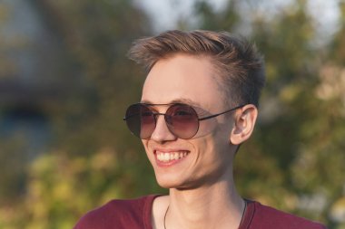 Gün batımında gözlüklü genç bir adam. Kameraya poz veriyorum.