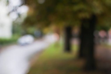 Arabanın camındaki bulanık görüntü. Yağmur sırasında şehrin sonbahar manzarası