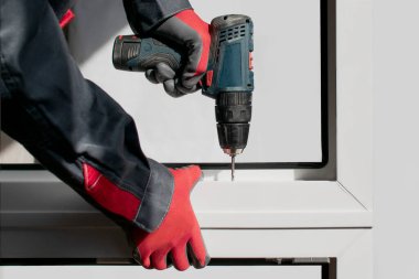 Çalışan bir kurucu pencere çerçevesini monte eder. Tornavidayı kullanarak elementleri bağla