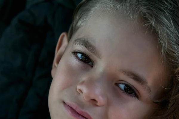 Kahverengi gözlü, karanlık bir odada küçük bir çocuk