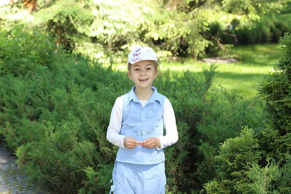 Pequena menina bonito em um parque de verão verde — Fotografia de Stock